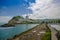 Close up of a rocky beach and buildings behind in a beautiful day in with sunny weather in a blue sky in Same, Ecuador