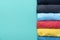 Close up of rolled colorful clothes on green background