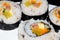 Close up of rolled rice sushi on a white plate arranged on a semi circle shape