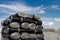 A close-up of rolls of new black roofing felt or bitumen that is precisely folded against a blue sky