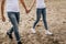 Close up of romantic couple hold hands and walk on sand