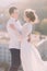 Close-up of a romantic newlywed couple looking at each other and embracing with their arms on city background