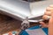 Close-up of a roofer applying weld into the gutter parts to assemble it.