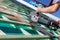 Close-up of a roofer using a hand circular saw