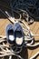 Close-up of a rope with a knotted end tied around a cleat on a wooden pier and shoes with anchors