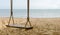 Close-up of Rope wooden swing hanging on tree at topical beach with sunlight in Thailand