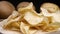 Close up of rotating potato chips with raw potato