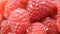 Close up of rotating Raspberries with waterdrop and flash of sunlight