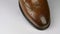 Close-up, rotation of a stylish classic brown shoe with laces.