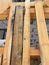 A close-up on rotten, damaged with mold and mildew wood, boards, timber and new untreated timber boards, planks on a brick house