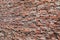 Close up of a rough brick wall with bricks on the left farther away than the right