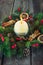 Close up round ivory burning Christmas candle on advent wreath with natural decor on the old rustic table. Christmas festive conce