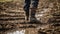 Close up of rubber boots in muddy field. Farmer inspects property after heavy rain and flooding