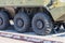 Close up on rubber tires with a large tread to overcome impassable roads and dirt on a Russian made green armored personnel