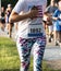 Close up of runner racing on a trial carrying a cell phone