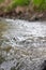 Close-up of rushing water, photo of wave texture and background. Waves of a small stream.
