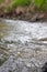 Close-up of rushing water, photo of wave texture and background. Waves of a small stream.