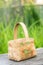 Close-up russian domestic birch bast basket with Khokhloma traditional painting on it on green grass background