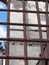 Close up of a rusting iron fence with bars in front of a ruined collapsing building