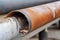 close-up of rusty downpipe being replaced with new galvanized steel pipe