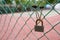 Close up of rusty padlock on wired fence