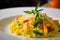 close-up of saffron risotto with diced vegetables and grated parmesan cheese on top