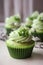 Close-up sage green cupcake decorated with a swirl of cream. Generative AI