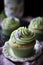 Close-up sage green cupcake delicately garnished with a cream swirl. Generative AI