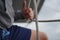 Close up of a sailors hand coiling up a rope, sheet on a sailboat