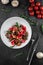 Close-up salad with boiled beef tongue, mushrooms, tomatoes and spinach on grey table. Traditional dish menu served in a