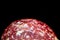 Close Up of a Salami Pepperoni Slice on Black Background Abstract View