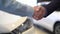 Close-up of salesman giving car keys to customer and shaking his hand.