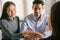 Close-up of salesman shaking hands with lovers who are customers In her office in the house purchase agreement Asian women and men