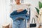 Close-up of saleswoman carrying clothing in a small retail store. Cropped shot of female holding a pile of jeans