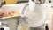 Close-up of a saleswoman slicing cheese in a supermarket.