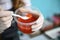 Close-up of salmon caviar in a jar in the hands of a fishmonger in a fish store. Delicacy seafood retail