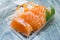 Close Up of salmon raw sashimi pack in clear plastic box on wooden table.