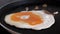 Close-up of salting one egg in a frying pan