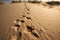 close-up of sand dunes and patterns, with footprints from a person visible