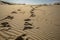 close-up of sand dunes and patterns, with footprints from a person visible