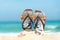 Close up sandals on the sand beach with starfish sandy beach. Summer and Holiday