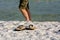 Close Up of Sandals on White Sand on Blur Man Legs Background. Destin Beach, Florida