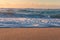 Close up of sandy beach shore with white foam of ocean waves