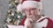 Close-up of Santa Claus reading letter and making displeased face. Senior man with white beard thinking on gift to