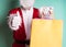Close up of Santa Claus with some gift bags giving a thumbs up isolated on blue background
