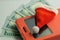 Close-up of a Santa Claus souvenir hat lying on a smartphone in a red case against the background of five hundred US dollars. The