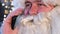 Close up of Santa Claus talking on smartphone. Young Santa Claus uses a gadget