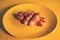 Close up of sausages in sauce with cherry tomatoes on yellow plate. Appetizing frankfurters with small red tomatoes and