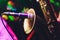 Close-up of a saxophonist playing his instrument, a saxophone, next to a microphone with pedestal. Black background.