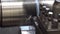 Close-up scene of lathe machine operation by cutting the metal tube by cutting tool.
